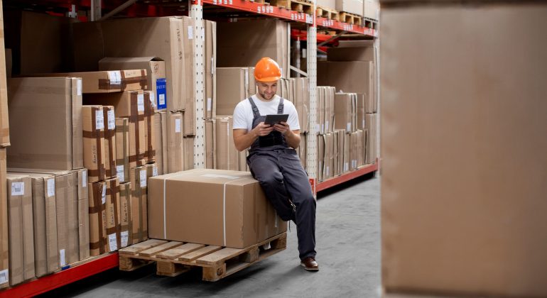 A man managing inventory in a warehouse.